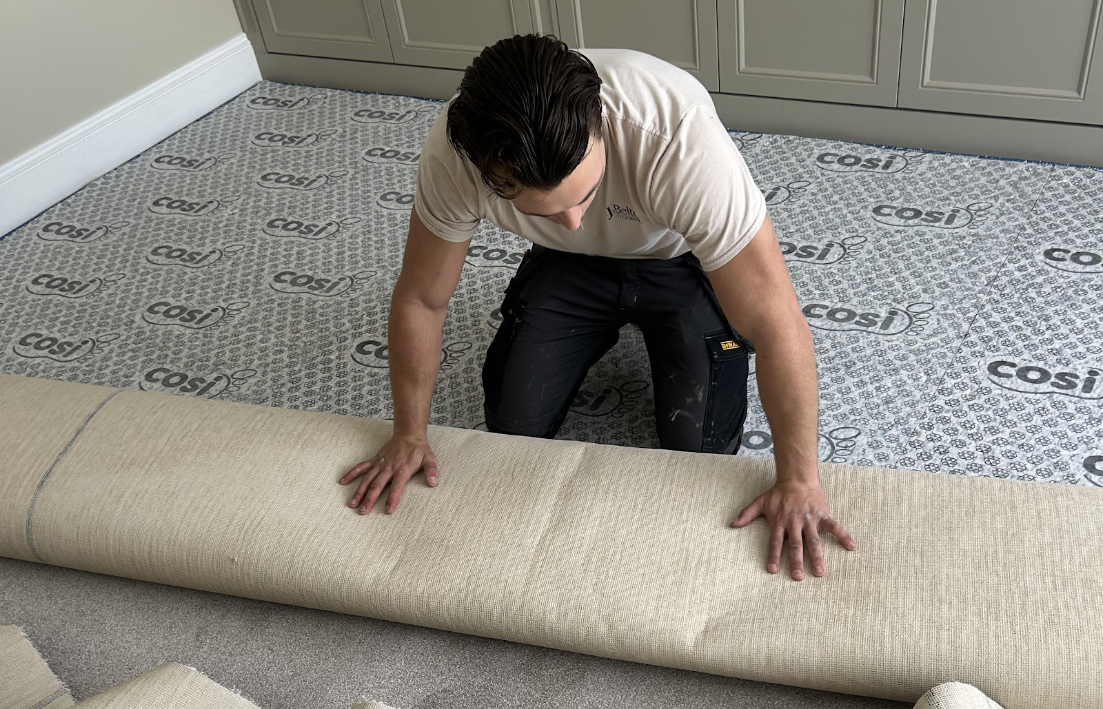 Fitting new carpet over fresh underlay in a bedroom — the everyday craft behind a clean finish.