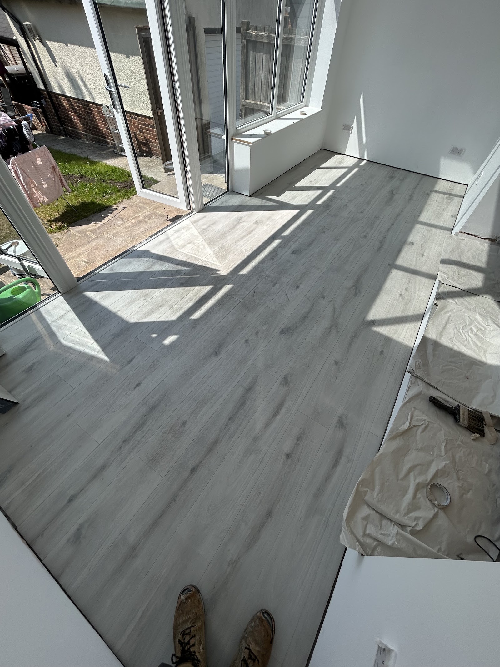 Grey oak laminate in a bright garden-room extension, run right up to the bi-fold doors.
