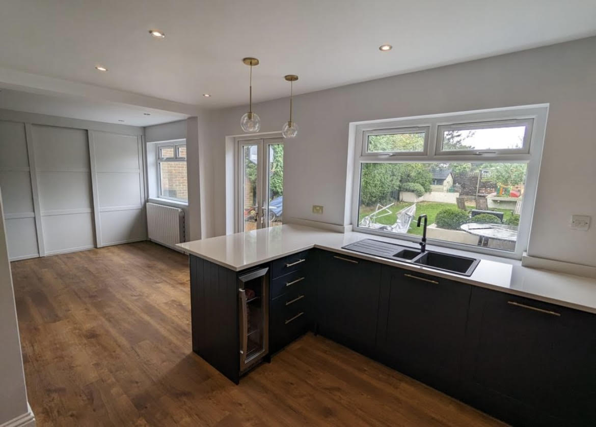 Warm oak plank flooring flowing through an open-plan kitchen-diner extension.